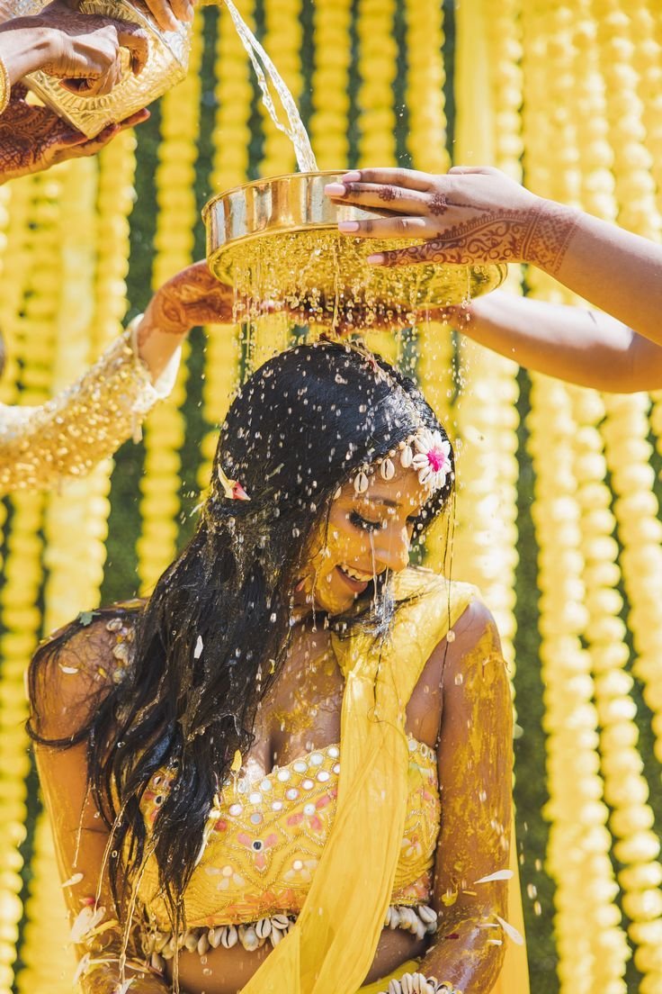 Bride during her Haldi ceremony, turmeric paste applied by family