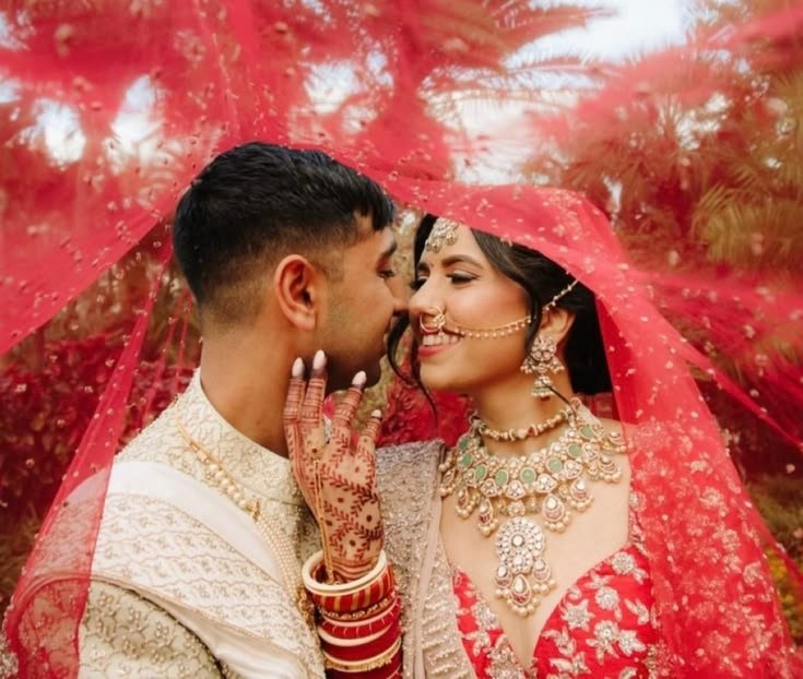 Bride in a red bridal lehenga walking toward the wedding mandap